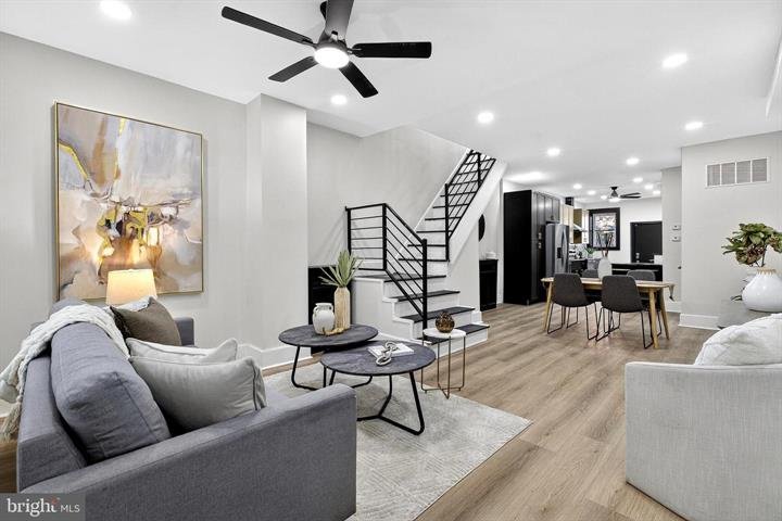 Living room with a gray sofa, round coffee tables and a staircase